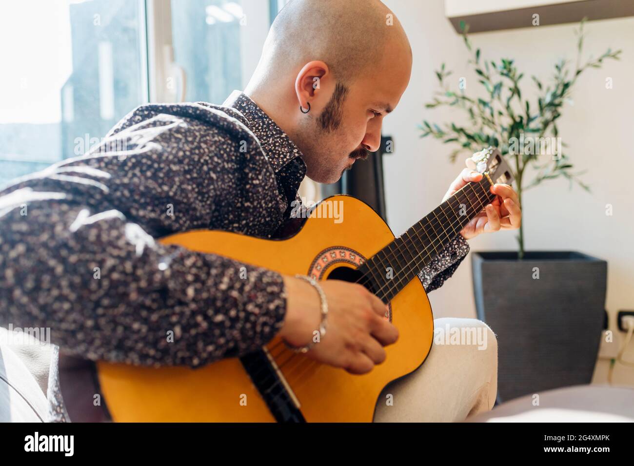 Man playing guitar at home Stock Photo