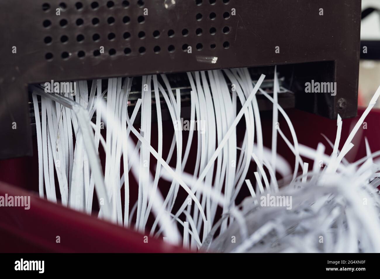 Shredding papers coming out from the machine. Shredding documents for security. Stock Photo