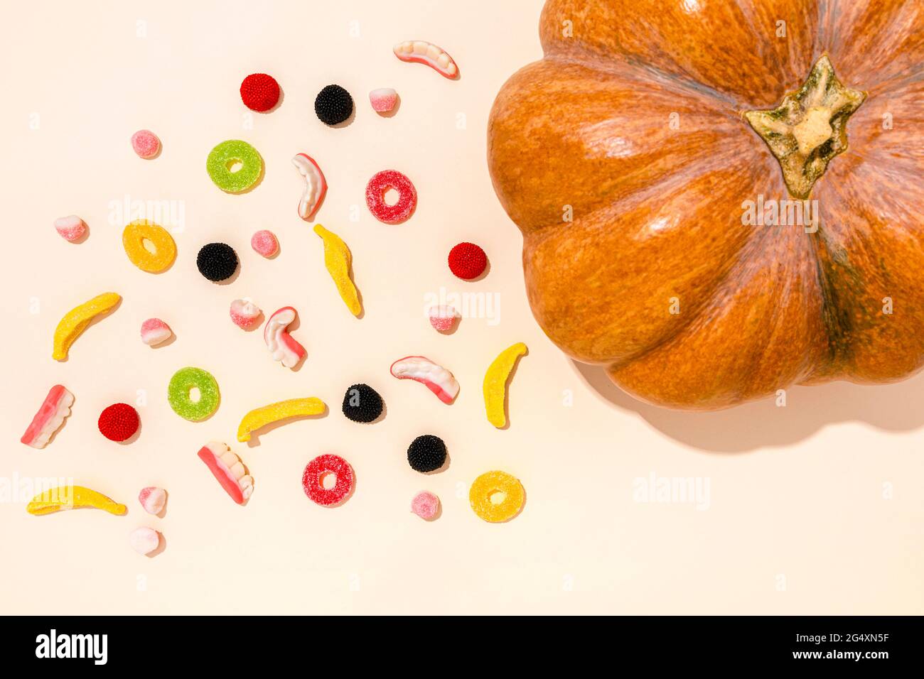 Studio shot of raw pumpkin and various Halloween candies Stock Photo