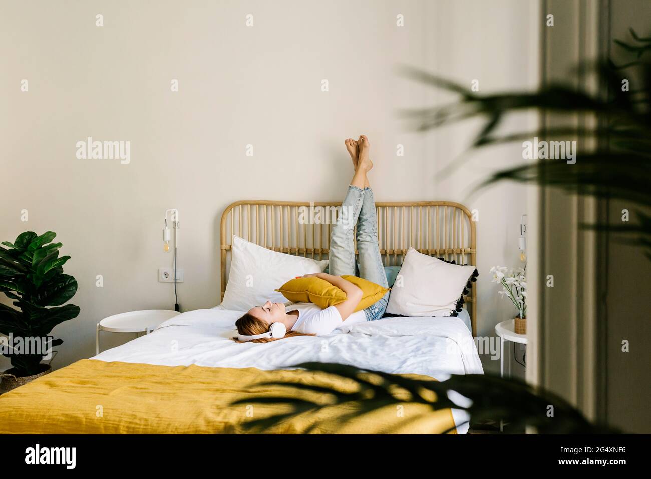 Young woman listening music while lying on bed at home Stock Photo - Alamy
