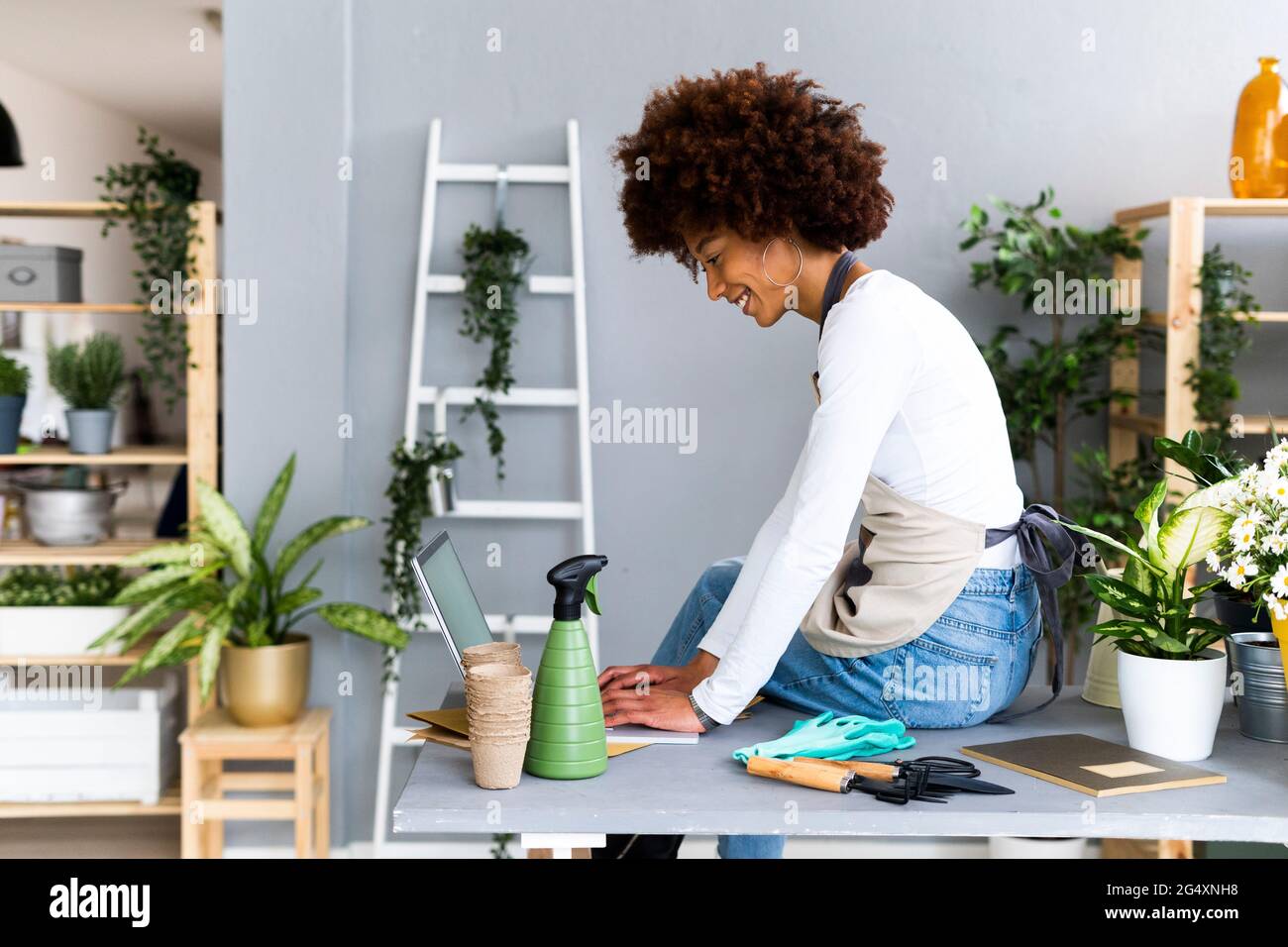Female shop owner using laptop while sitting on table Stock Photo