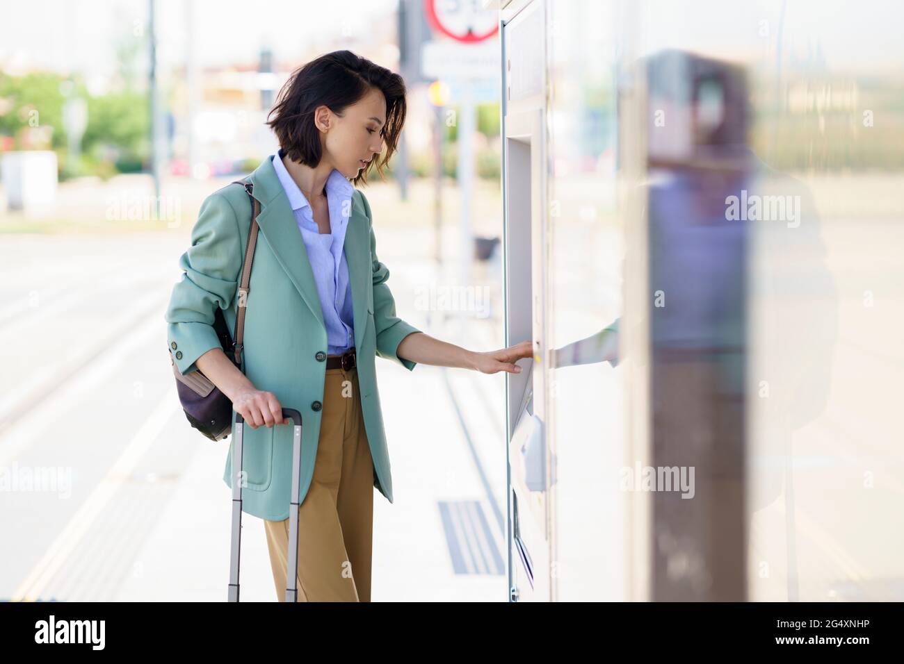 Businesswoman buying train ticket at railroad station Stock Photo - Alamy