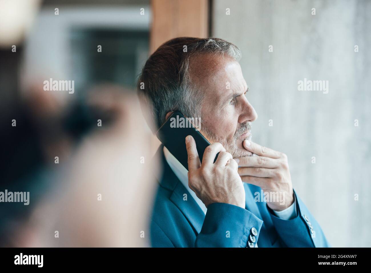 Senior businessman talking on mobile phone in office Stock Photo