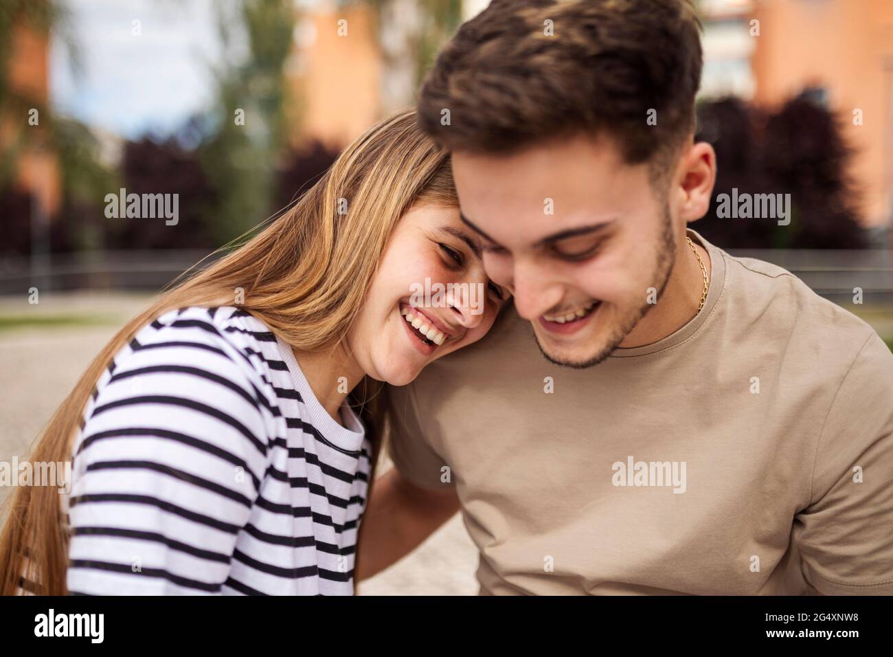 Smiling girlfriend with head on shoulder of boyfriend Stock Photo