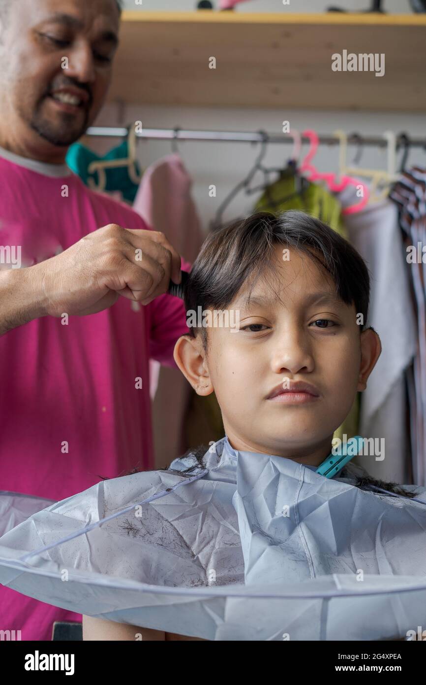 Asian child getting haircut at home from the father Stock Photo Alamy