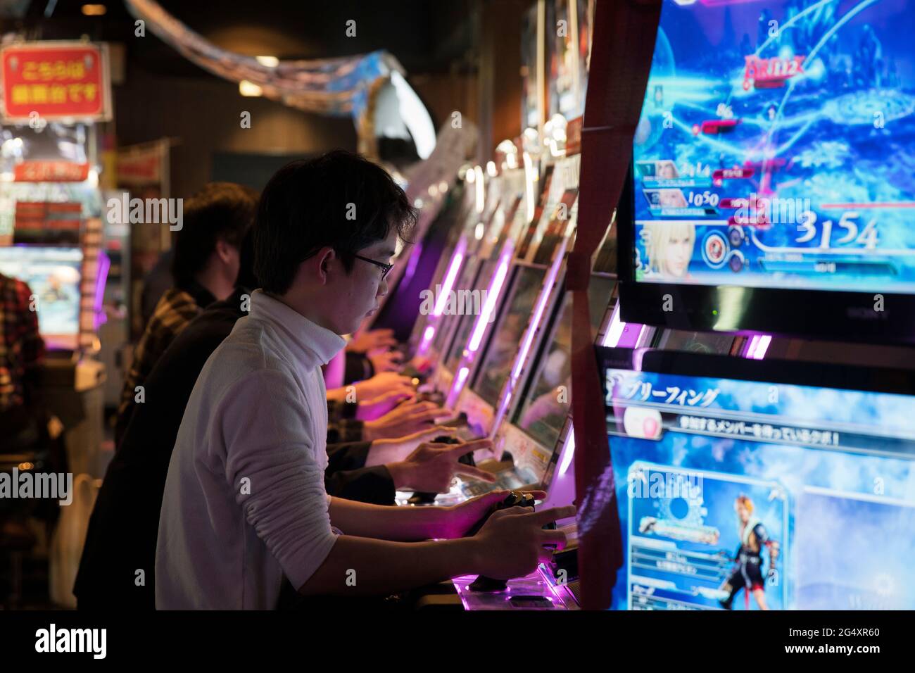 People playing videogames in a Japanese arcade Stock Photo