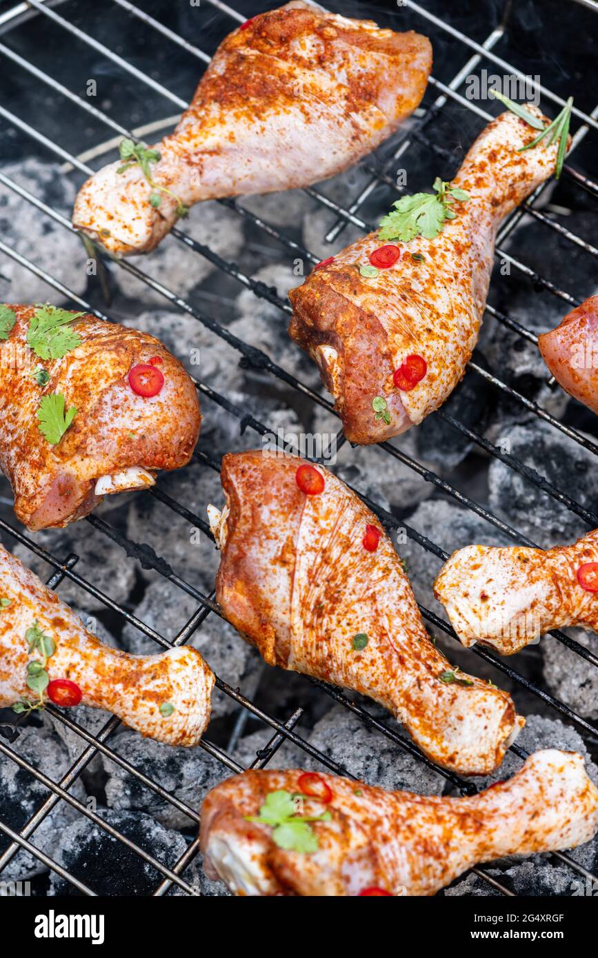 Chicken Drumstick Legs Grilling on Charcoal BBQ. Summer Picnic Food in Backyard Garden Stock