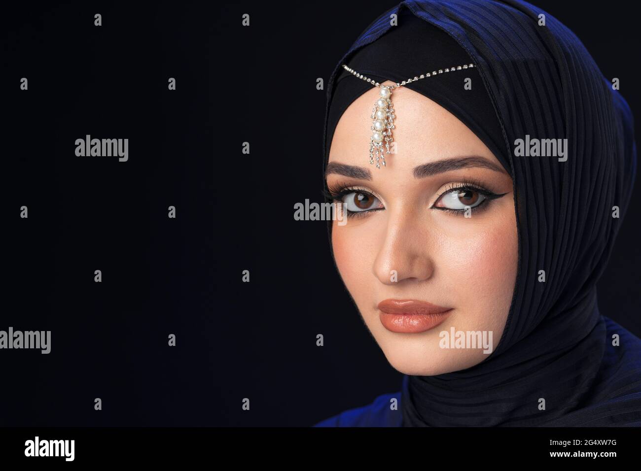 Portrait of a young muslim woman in hijab on black background Stock ...