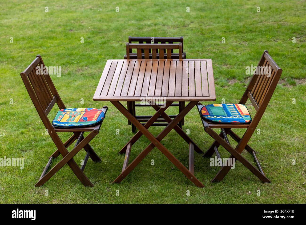 wooden table and chairs on the garden lawn Stock Photo - Alamy