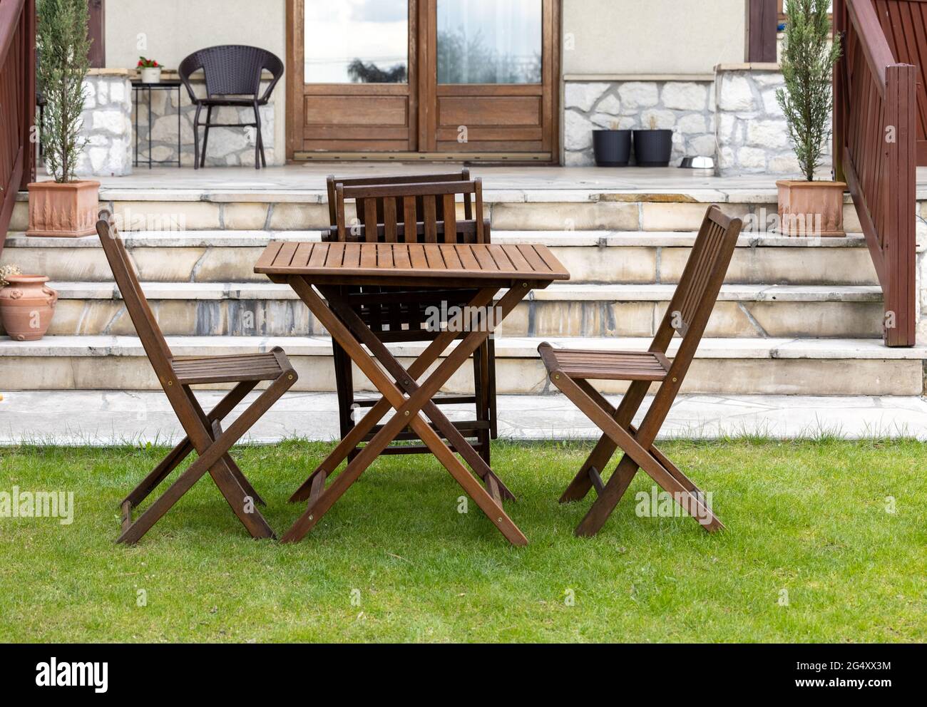 wooden table and chairs on the garden lawn Stock Photo - Alamy