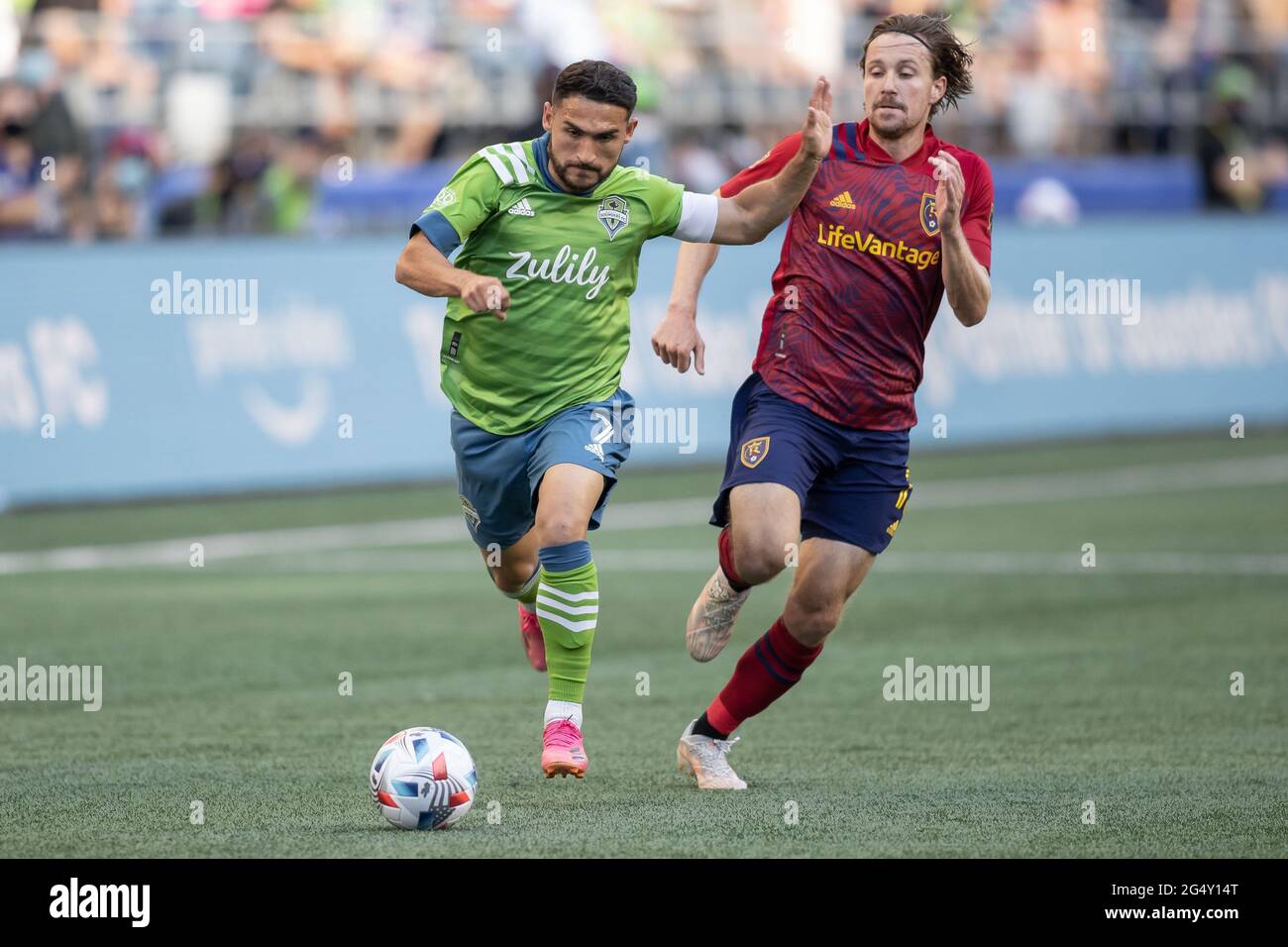 Seattle Sounders midfielder Cristian Roldan (7) running with the ball past Real Salt Lake midfielder Nick Besler (13) during the first half of an MLS Stock Photo