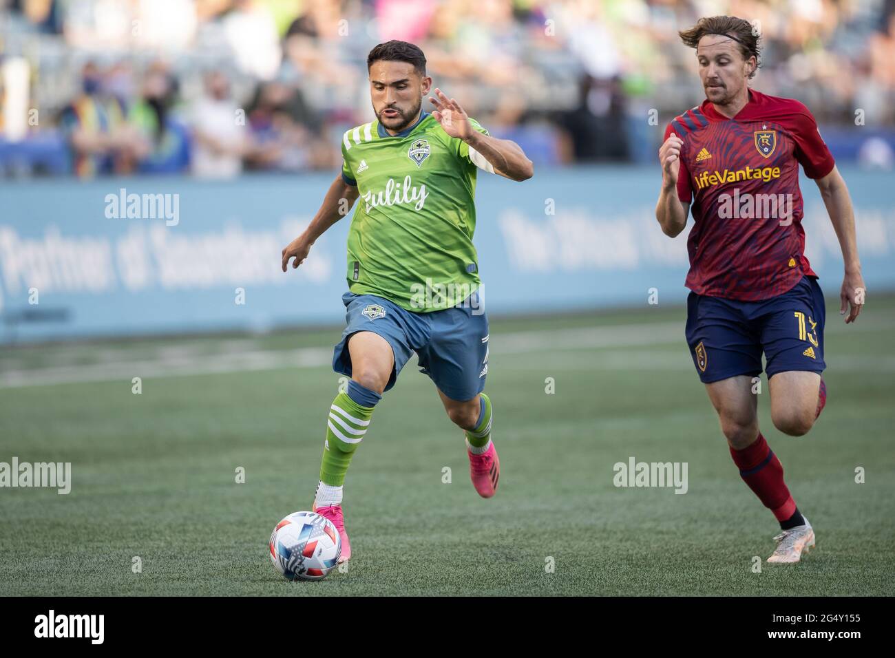 Seattle Sounders midfielder Cristian Roldan (7) running with the ball past Real Salt Lake midfielder Nick Besler (13) during the first half of an MLS Stock Photo