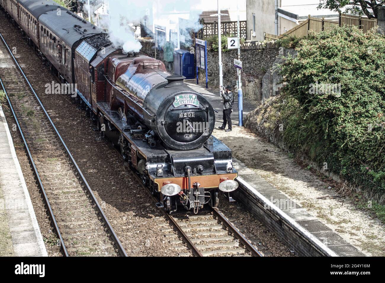 The Cathedrals Express Passing through Dockyard Halt station in Plymouth. Train pulled by the Princess Elizabeth locomotive 6201. A wellwisher waves t Stock Photo