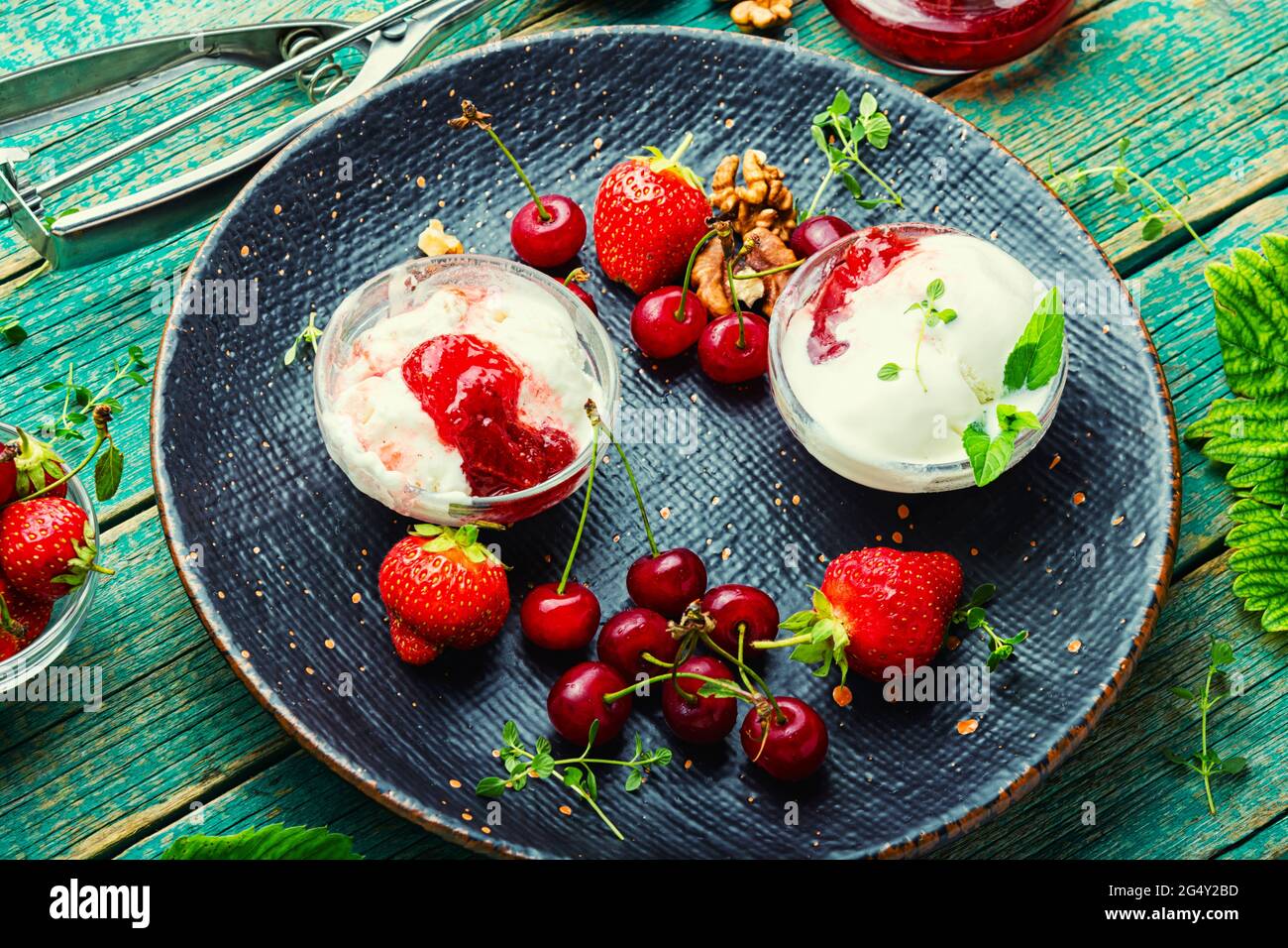 Summer dessert, ice cream with strawberries and cherries.Ice cream with berry jam on wooden table Stock Photo