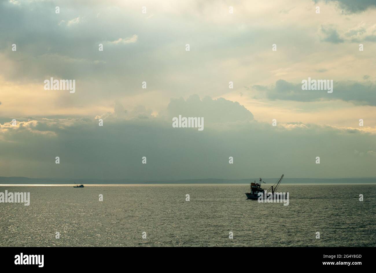 Cloudy sky with fishing boat at sunset in the Black Sea Stock Photo - Alamy