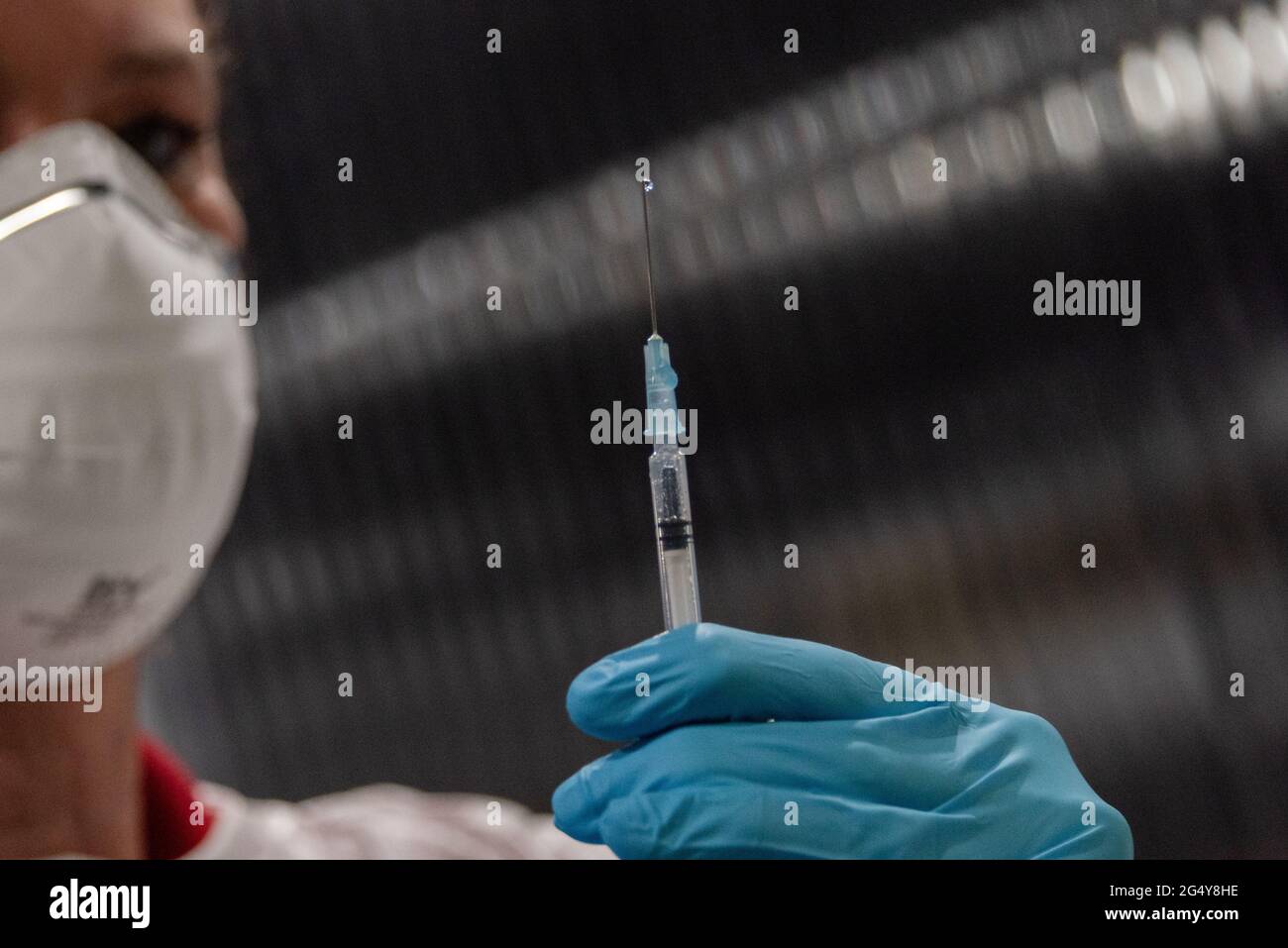 Aufziehen einer Impfdosis aus der Impfstoffampulle in die Injektionsspritze durch einen Arzt Stock Photo
