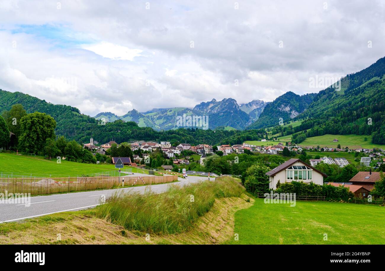 View on alps mountain, green fields  Bulle, Canton Fribourg, Freiburg nearby Castle  Greyerz. Good hiking tourist way. Switzerland Stock Photo