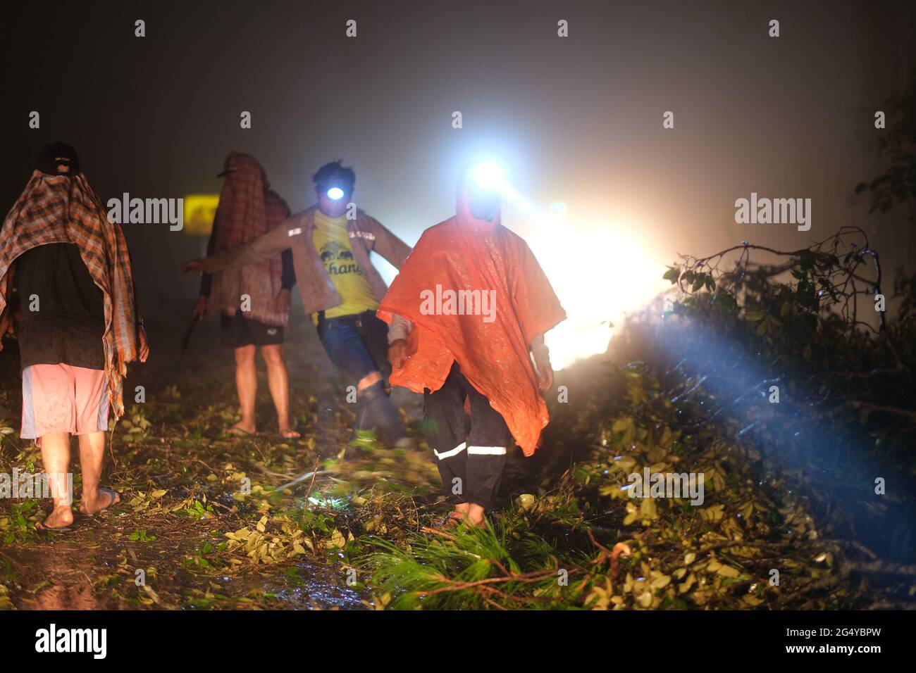 A volunteers are removing a blockage of fallen trees after storm on a distant road in a highlands of northern Thailand, at evening of 4th June 2021 Stock Photo