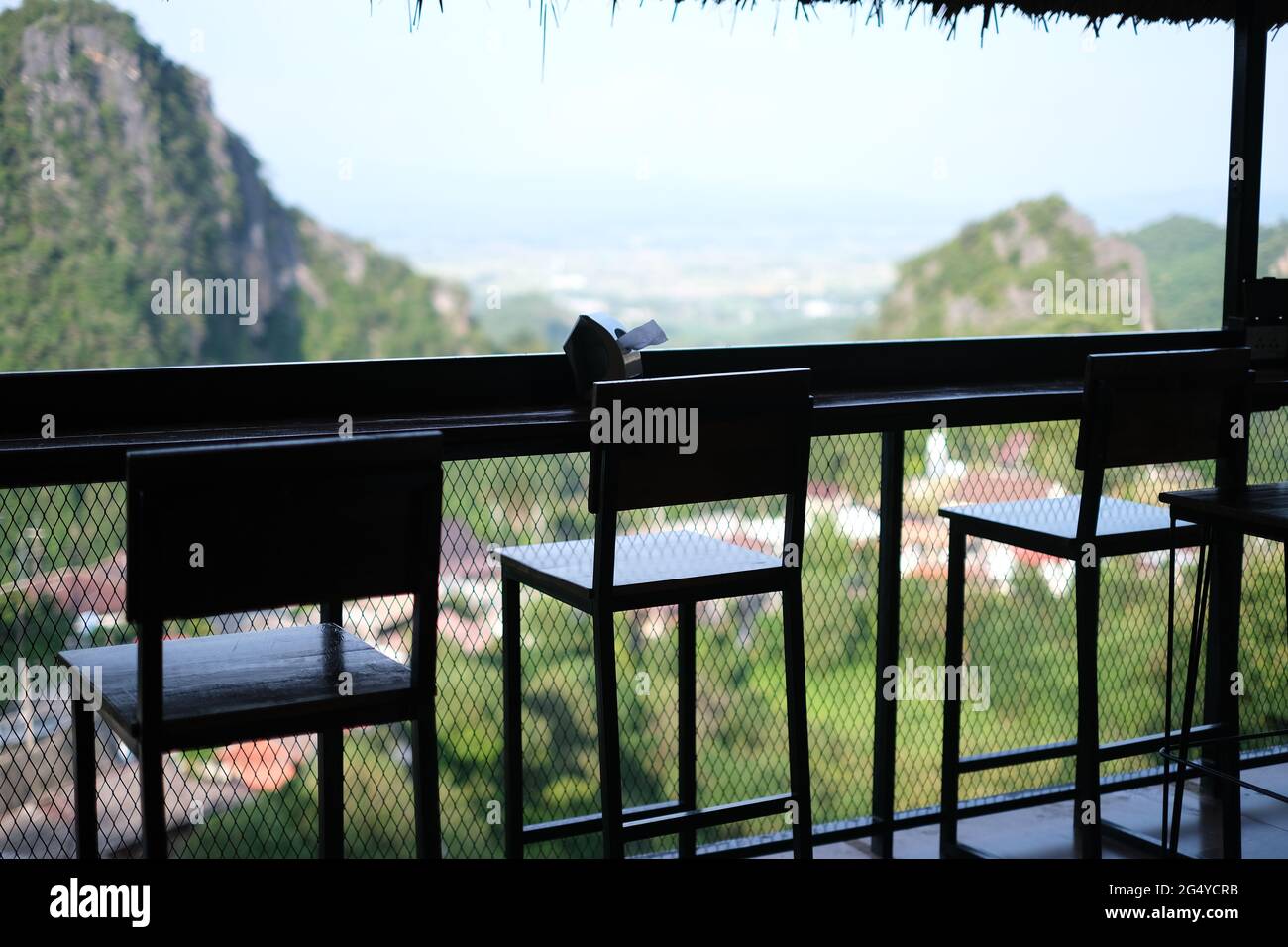 Three empty chairs in a coffeeshop on top of a mountain, with an idyllic view Stock Photo