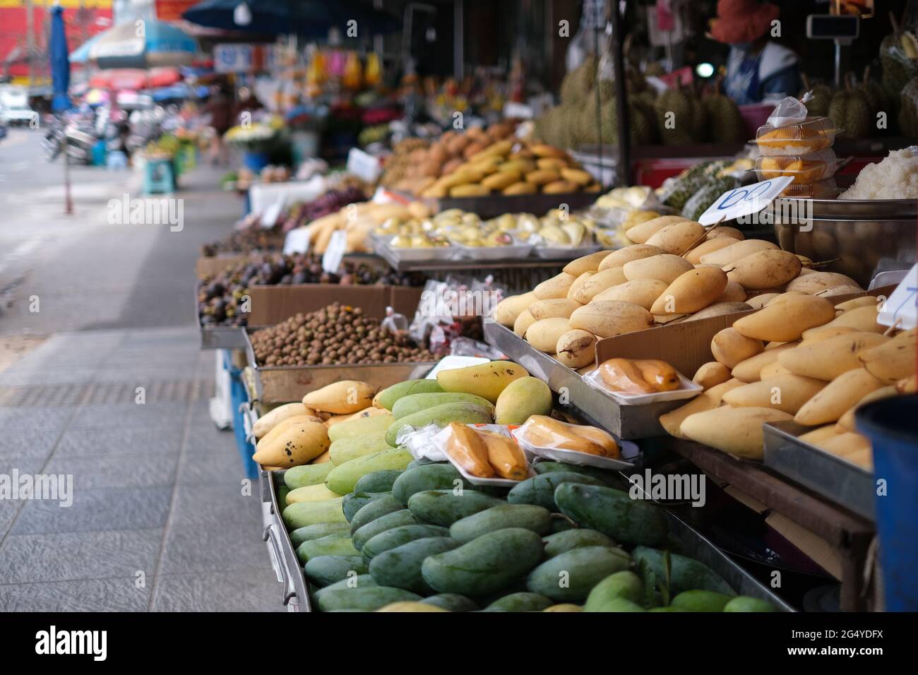 Stalls at a typical street market in Thailand, full of fresh fruits and vegetables Stock Photo