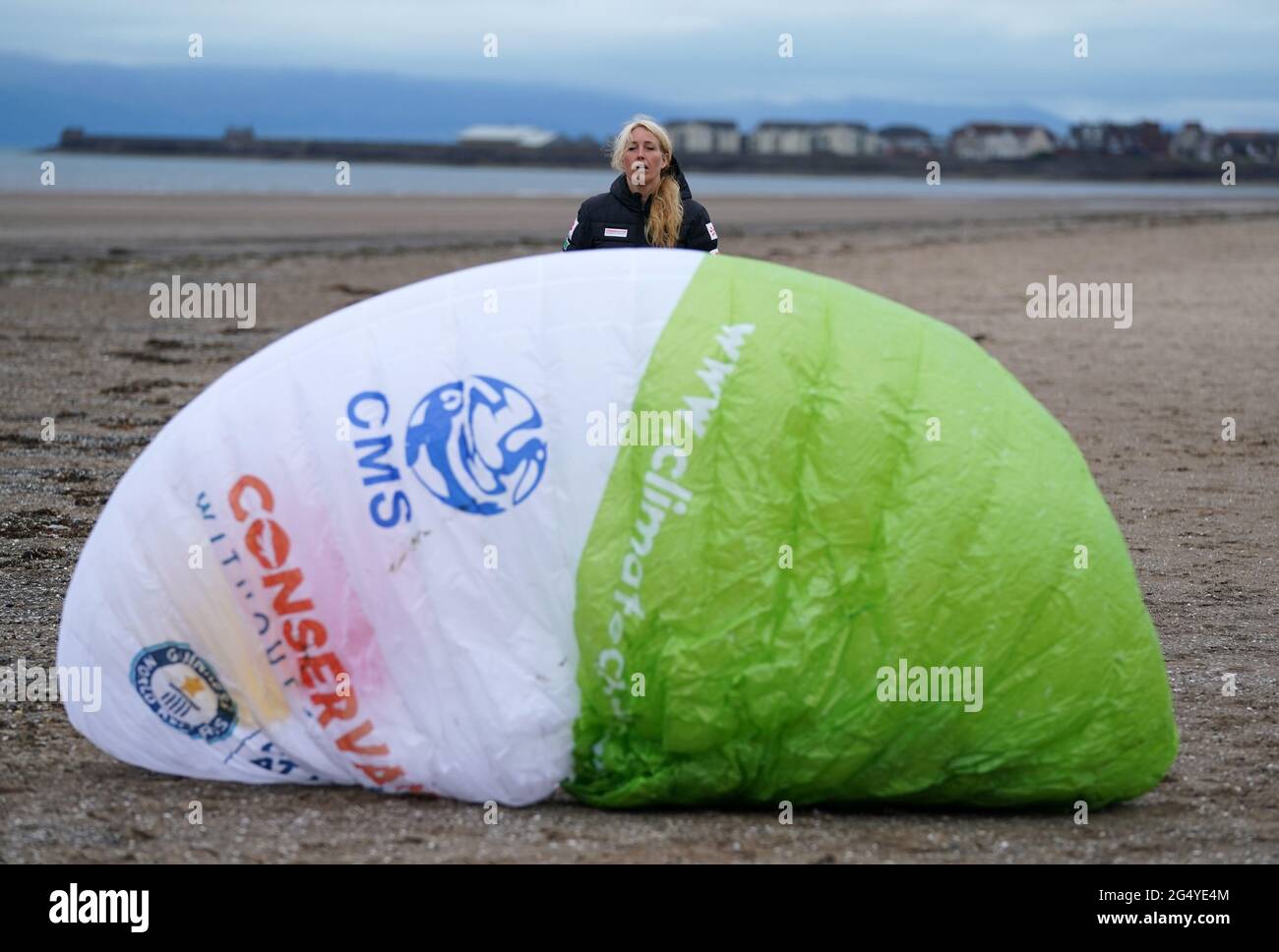 Paramotorist Sacha Dench with her glider as she checks the weather on the beach at Stevenston to see if the conditions are right for flight. Picture date: Thursday June 24, 2021. Stock Photo