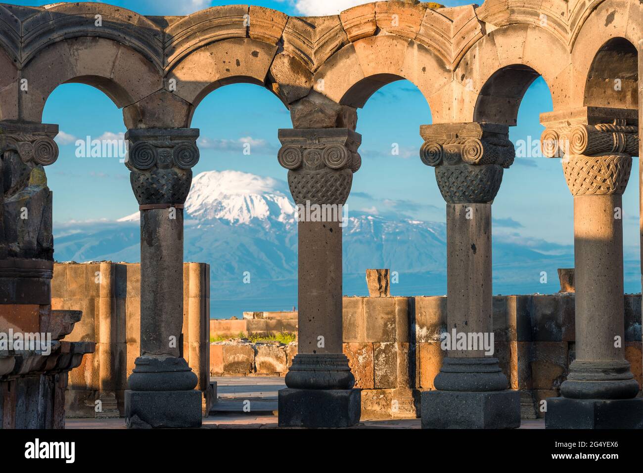 Columns of the ancient Zvartnots temple on the background of high snow-capped Mount Ararat, a tourist attraction Stock Photo