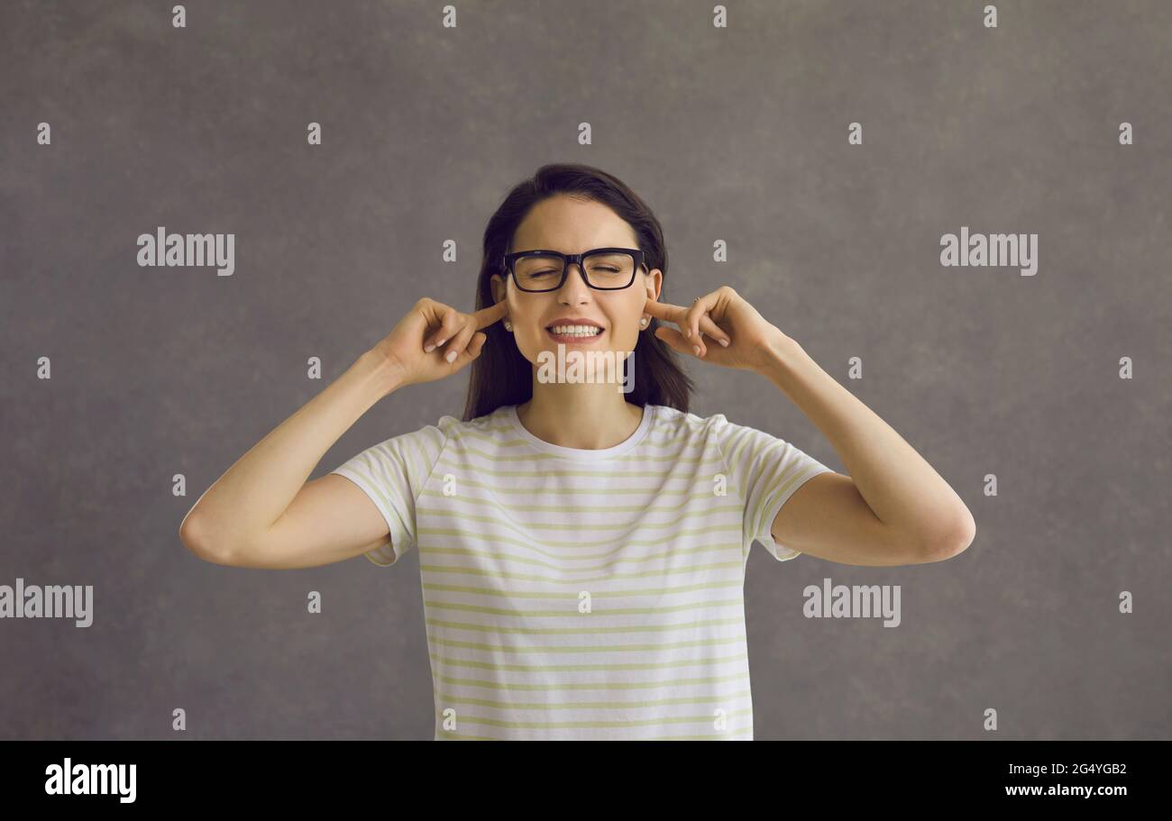 Headshot of woman closing ears with fingers to ignore loud noise or unsolicited advice Stock Photo