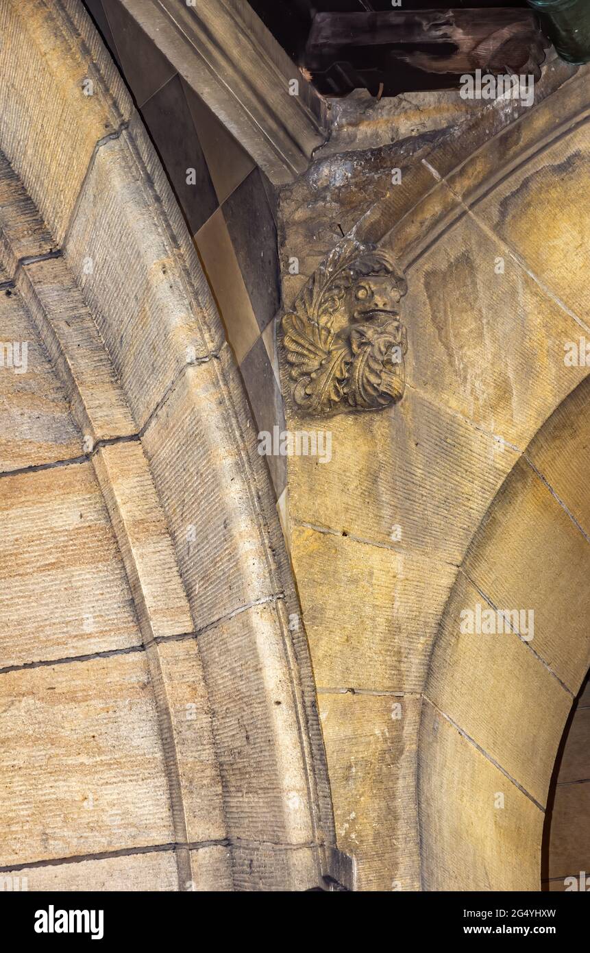 Exterior architectural detail in the form of a frog-like grimace, in the arcaded courtyard of the Church of Reconciliation, Dresden, Saxony, Germany. Stock Photo
