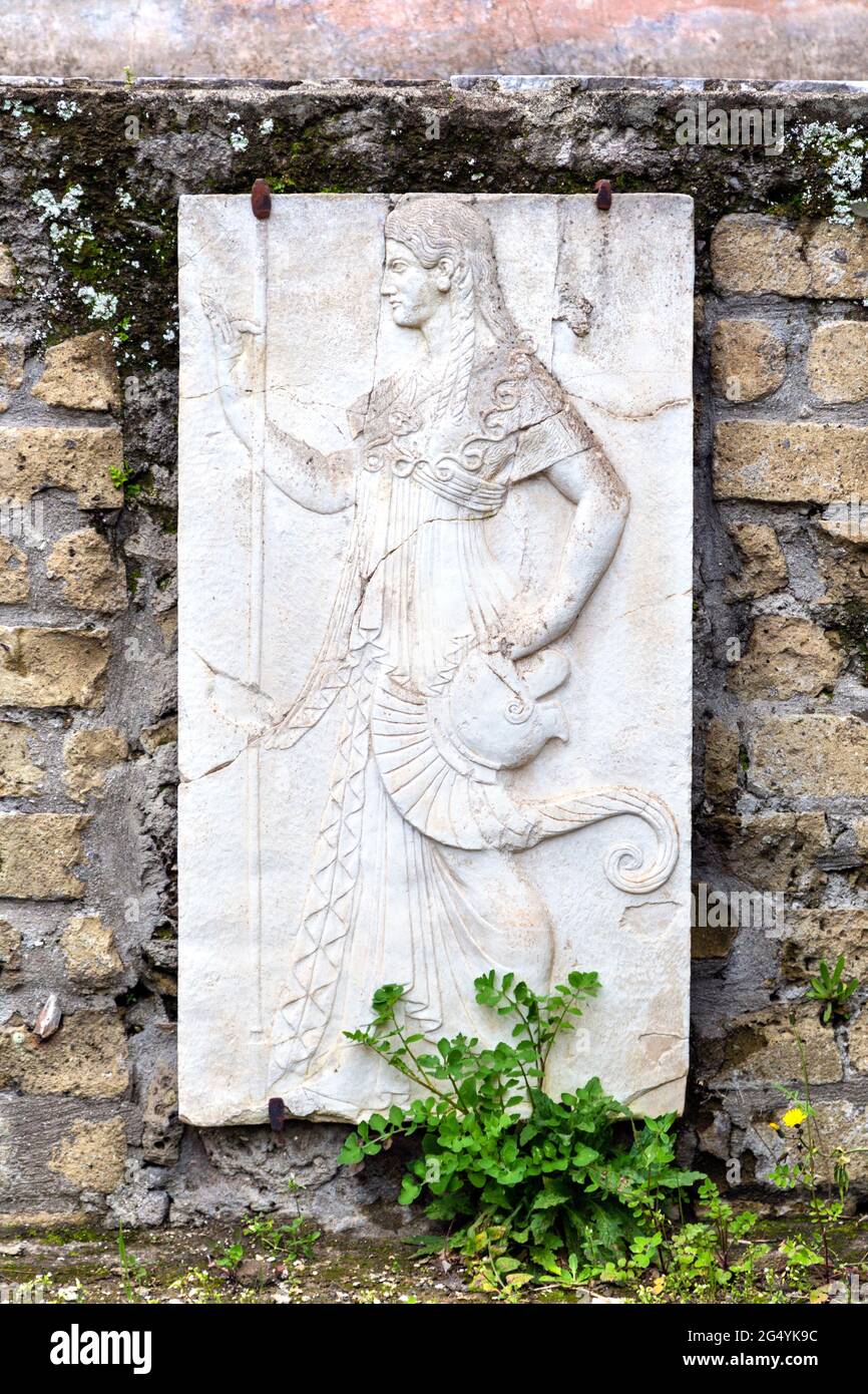 Carved marble relief of Roman goddess Minerva, shrine of the four gods (Sacello dei Quattro dei) at the Ancient City of Herculaneum, Campania, Italy Stock Photo