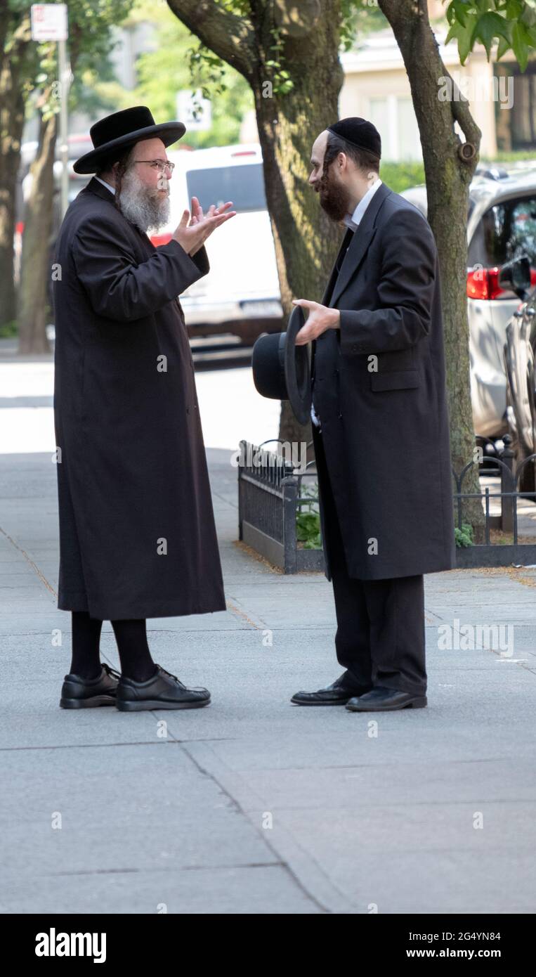 Two Hasidic men, likely from the Satmar group,  have a lively animated conversation in Williamsburg, Brooklyn, New York City. Stock Photo
