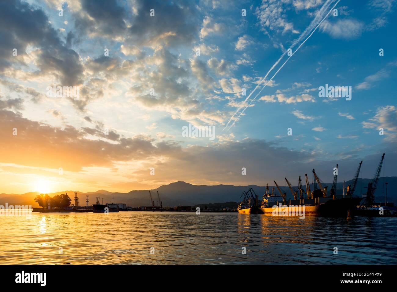 seaport and cargo cranes at sunse Stock Photo