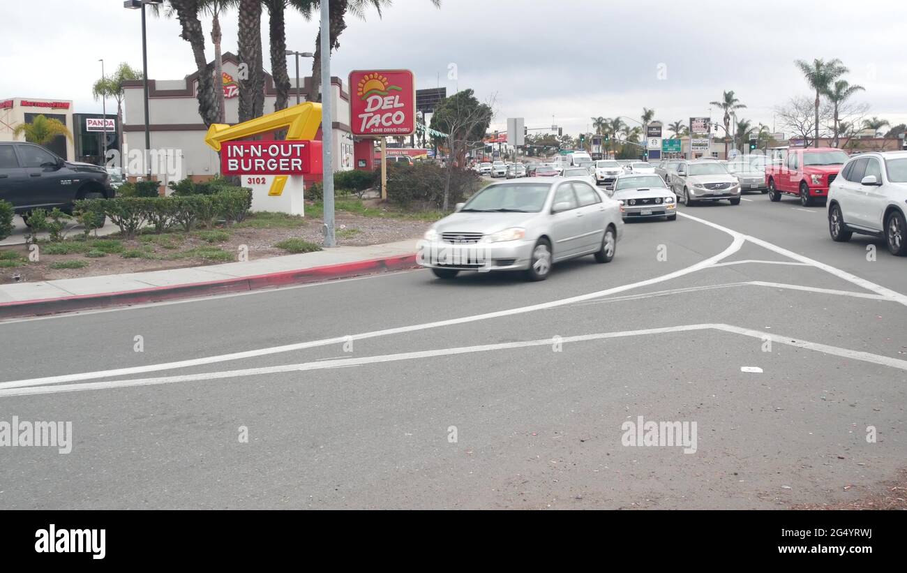 San Diego, California USA - 24 Dec 2020: Fast food restaurants on city street. In-n-out Burger drive thru, Del Taco logo, marketing advertising signs Stock Photo