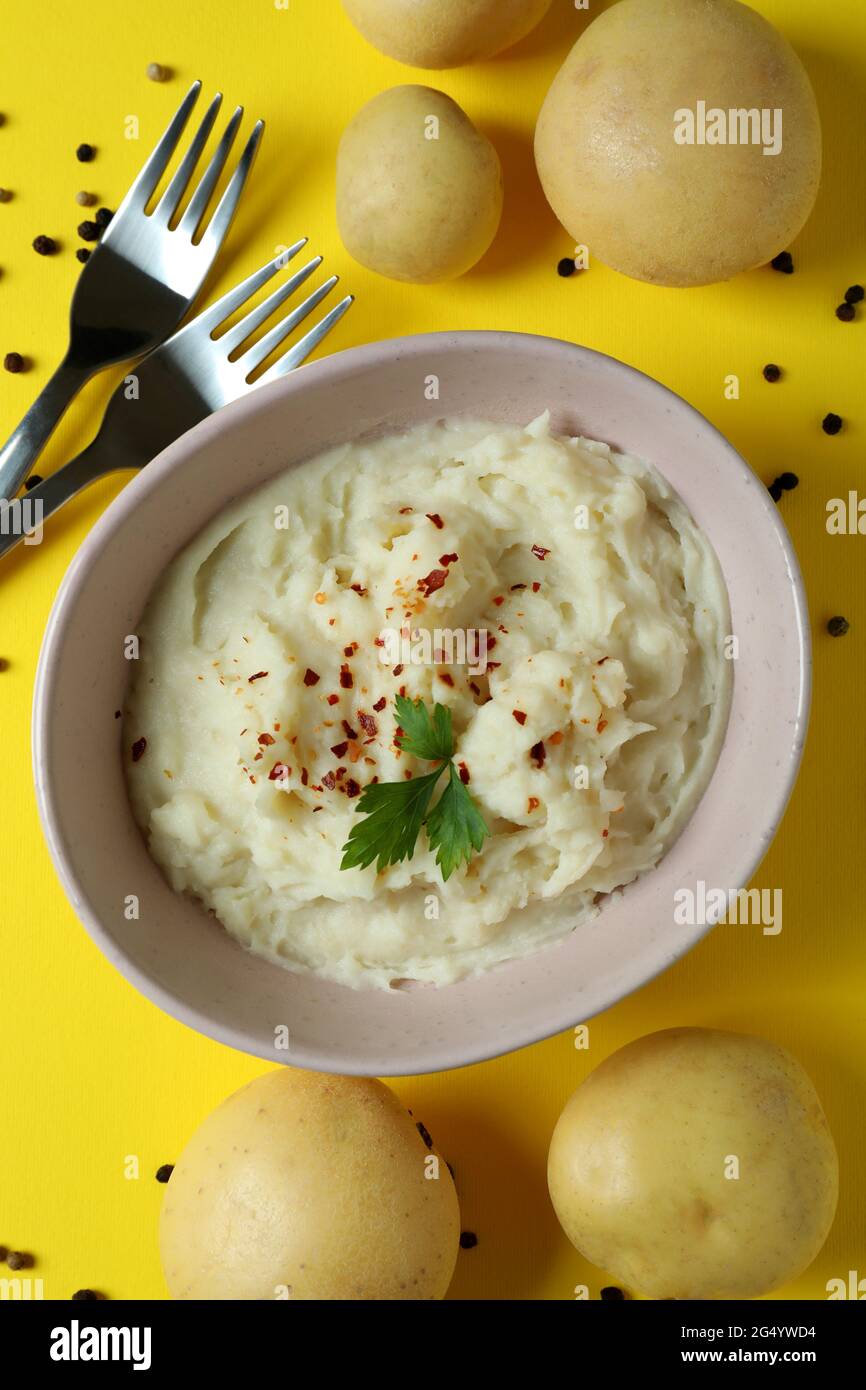 Plate of mashed potatoes and ingredients on yellow background Stock Photo