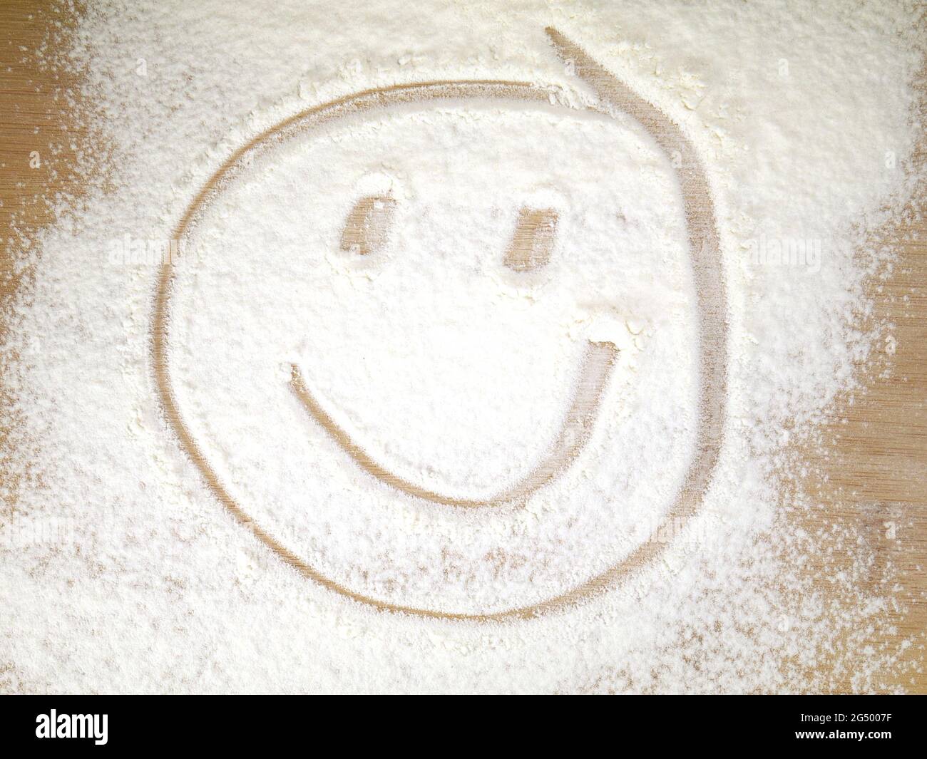 Smiling face on sprinkled flour Stock Photo