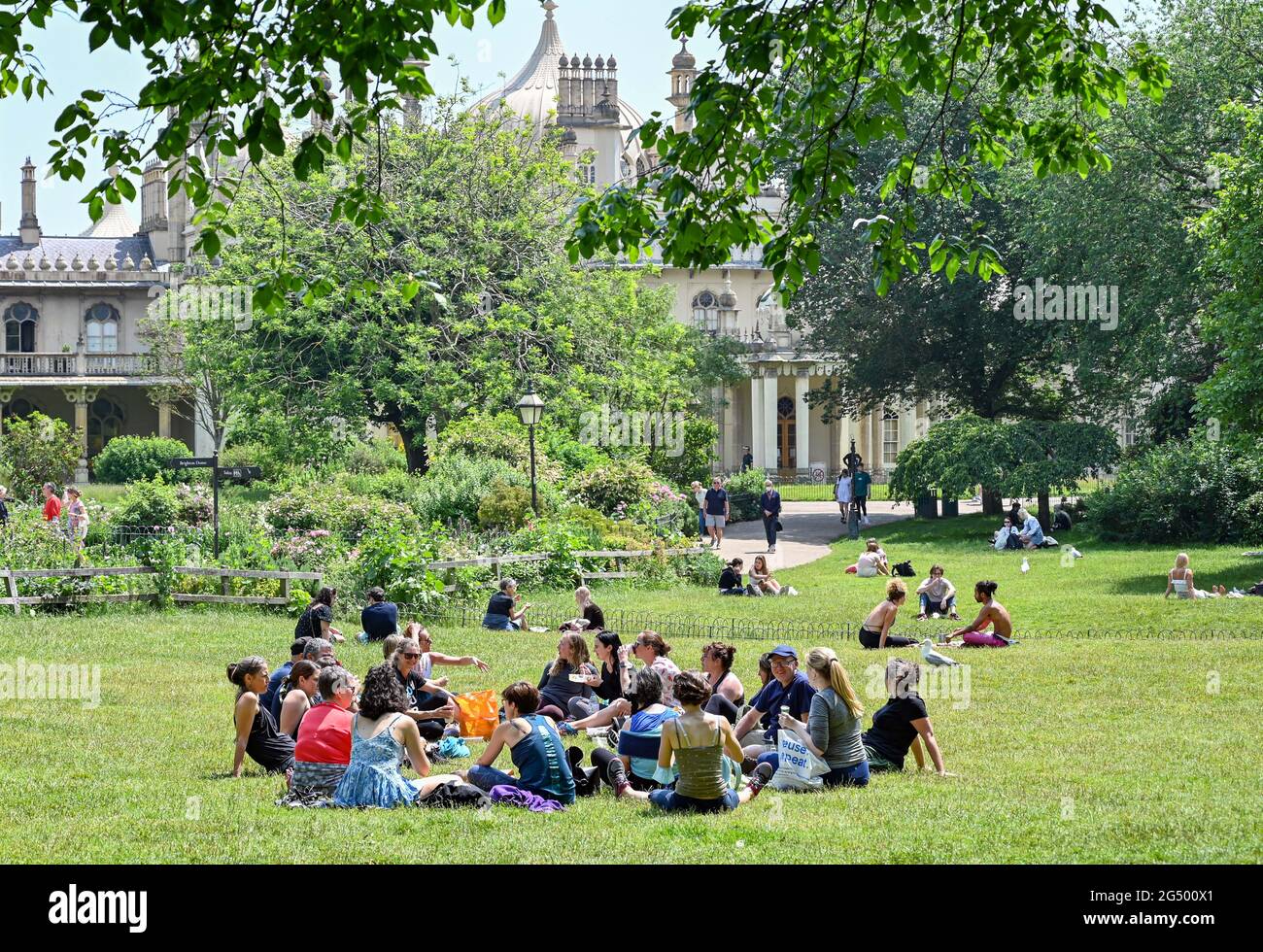 Brighton UK 24th June 2021 - Sunbathers enjoy a break in Pavilion Gardens Brighton on a beautiful warm sunny day. : Credit Simon Dack / Alamy Live News Stock Photo