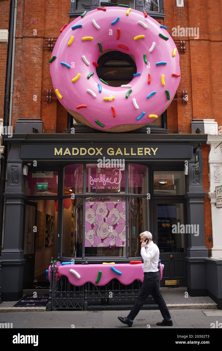 A giant donut installation outside the Maddox Gallery in Mayfair, London, to celebrate a new exhibition entitled Villainy, a body of work by an anonymous street artist from New York who operates under the alias, 'Jerkface'. Picture date: Thursday June 24, 2021. Stock Photo