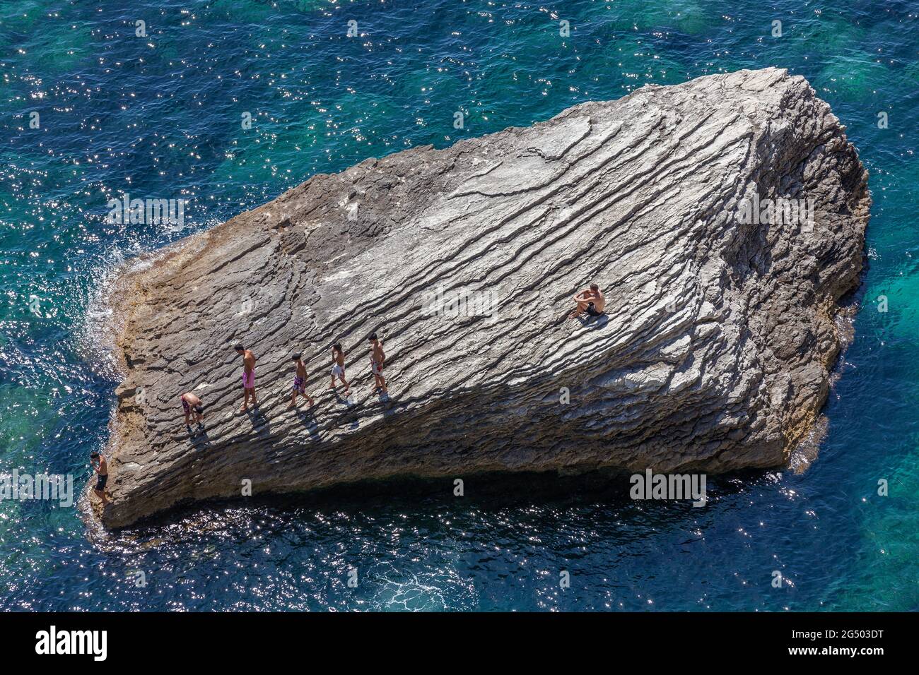 People walking on a rock emerging from the sea. Bonifacio, Corsica, France Stock Photo