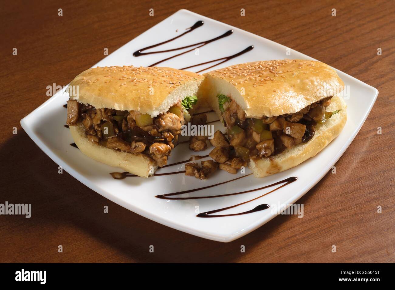 Pulled sandwich with pieces of fried chicken meat and pickles on a plate Stock Photo