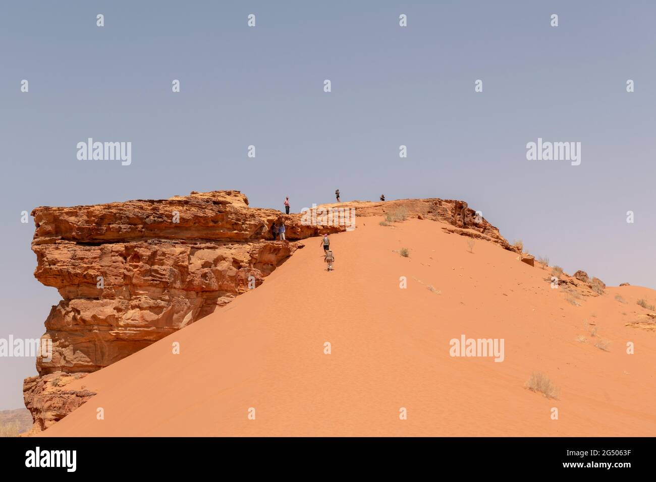 Tourists exploring the Wadi Rum Protected Area. Wadi Rum or Valley of the Moon is famous for its stunning desert landscape, desert valleys and dunes. Stock Photo