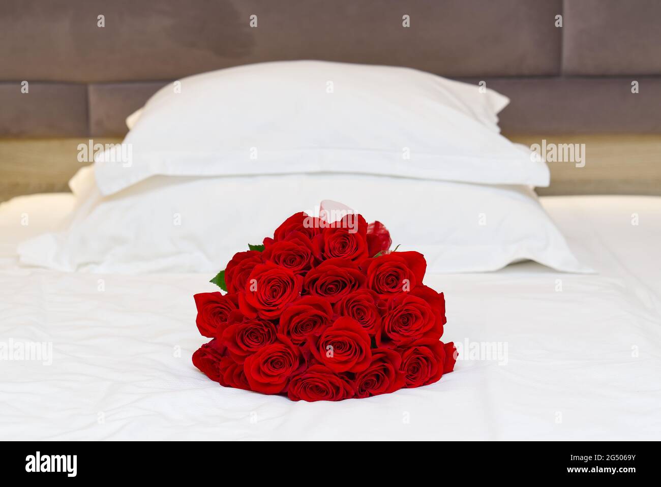 bouquet of red roses on the bed in a hotel room for honeymoon. romantic  meeting of guests at the hotel Stock Photo - Alamy