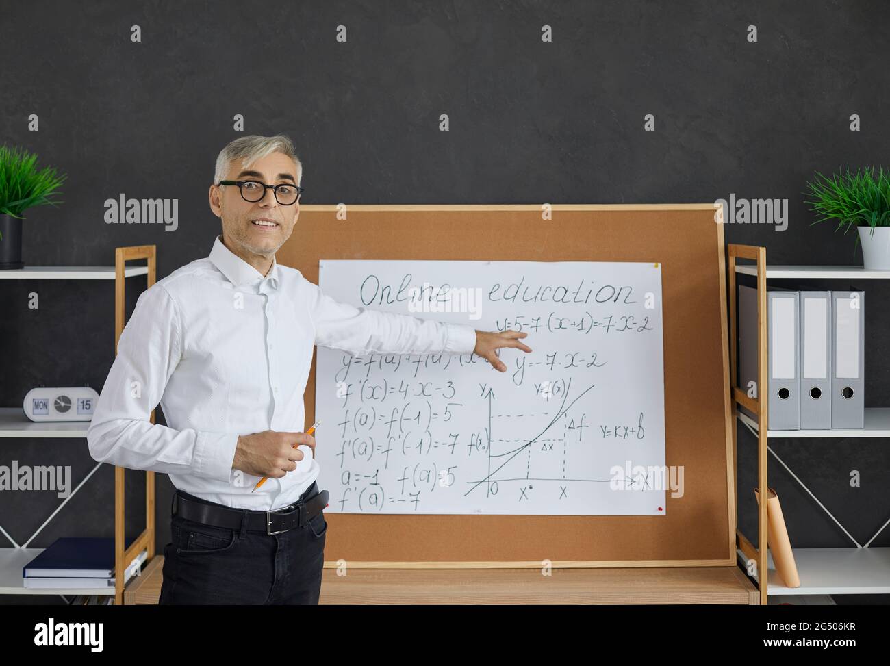 Senior male math and geometry teacher explains the new material to the students via a video call. Stock Photo