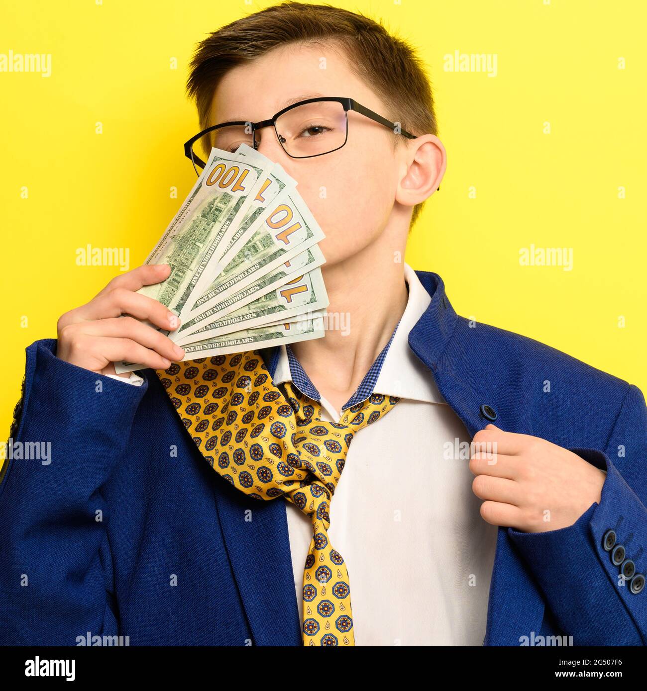 A guy in a big classic suit on a yellow background holds a foreign
