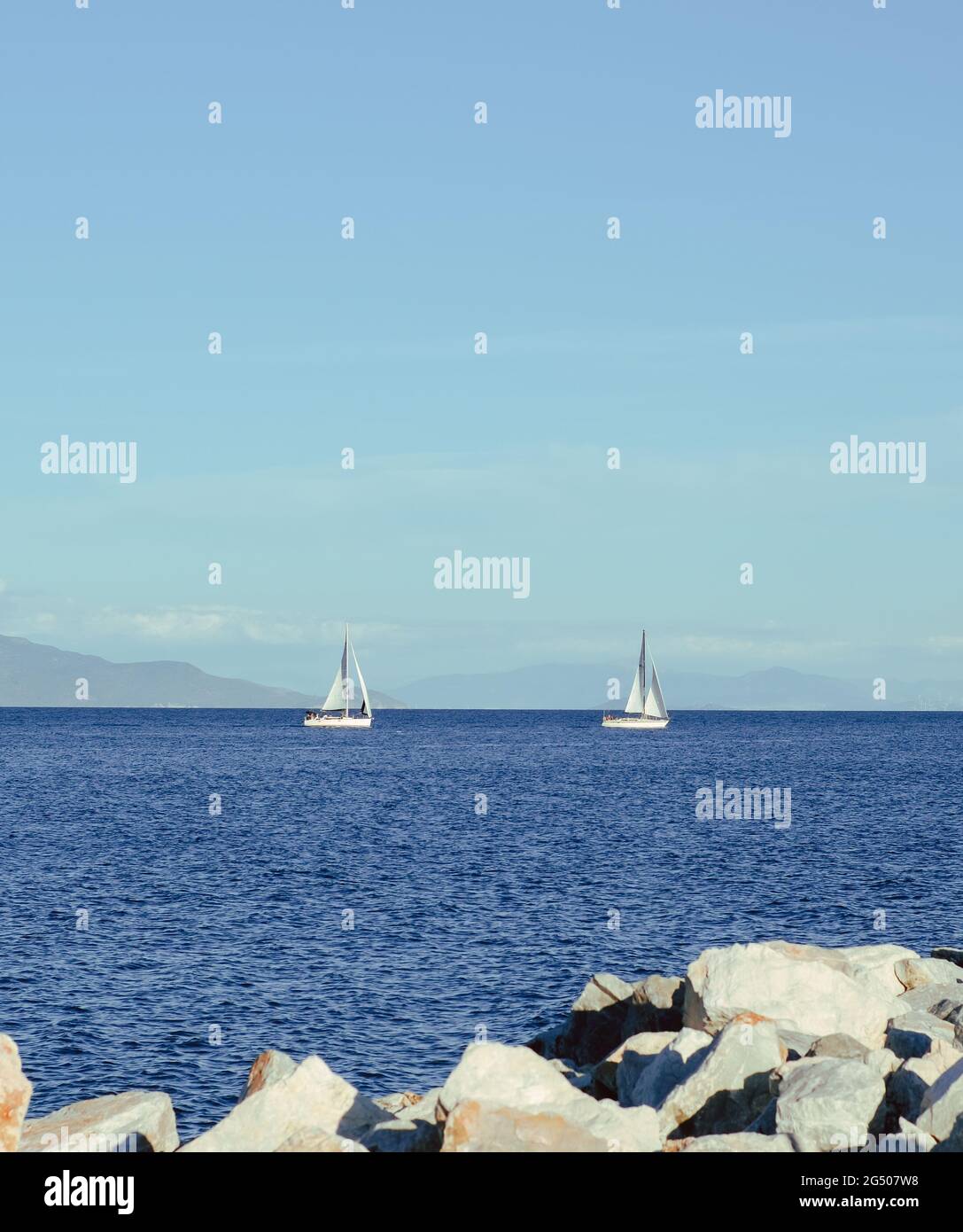 Vertical shot of sailboats on the calm sea in Mitilini, Lesbos, Greece Stock Photo