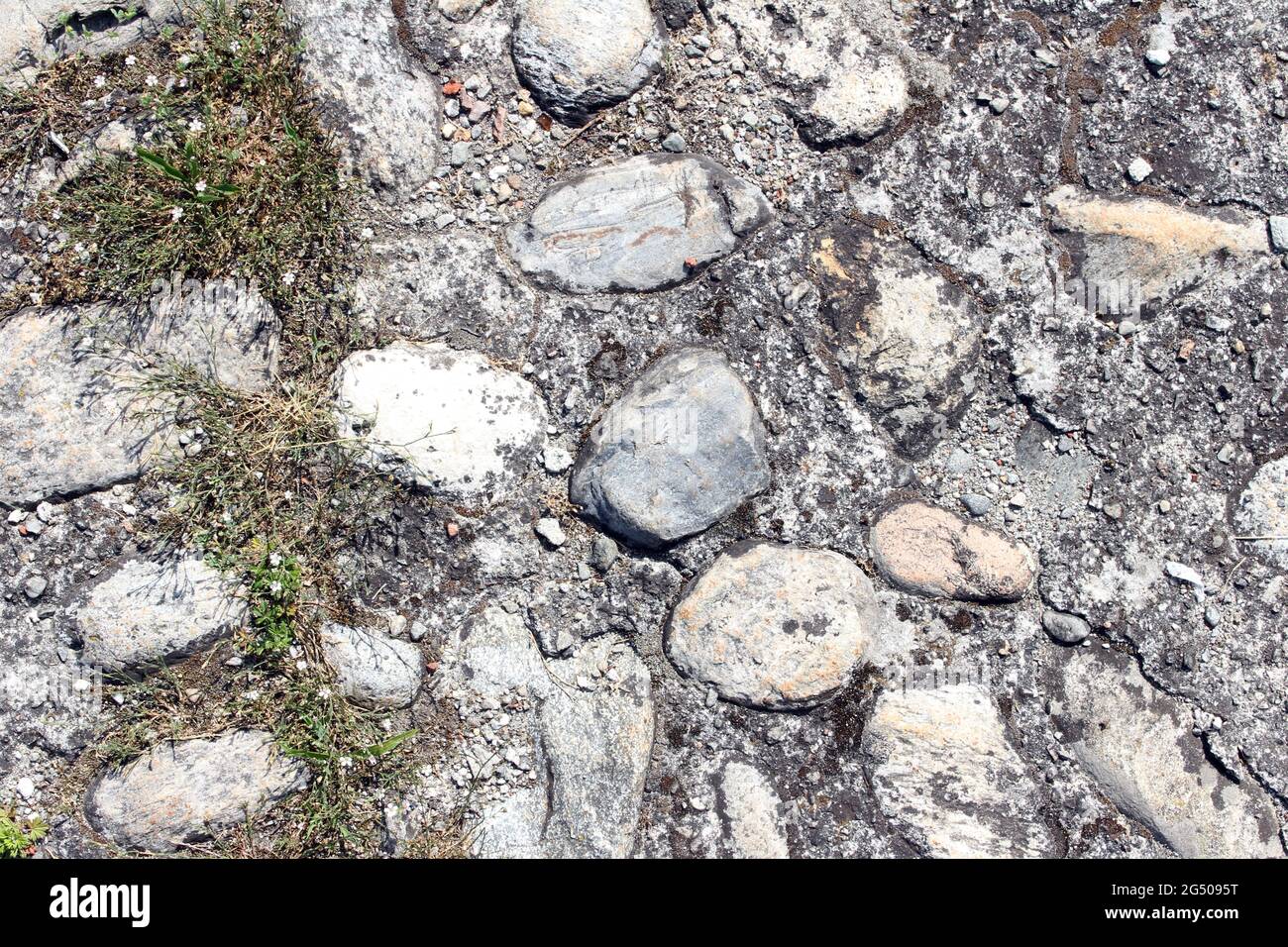 Pedestrian street in stones and cement, abstract texture background. Many granite stones in cement or concrete surface, pattern on exterior building Stock Photo