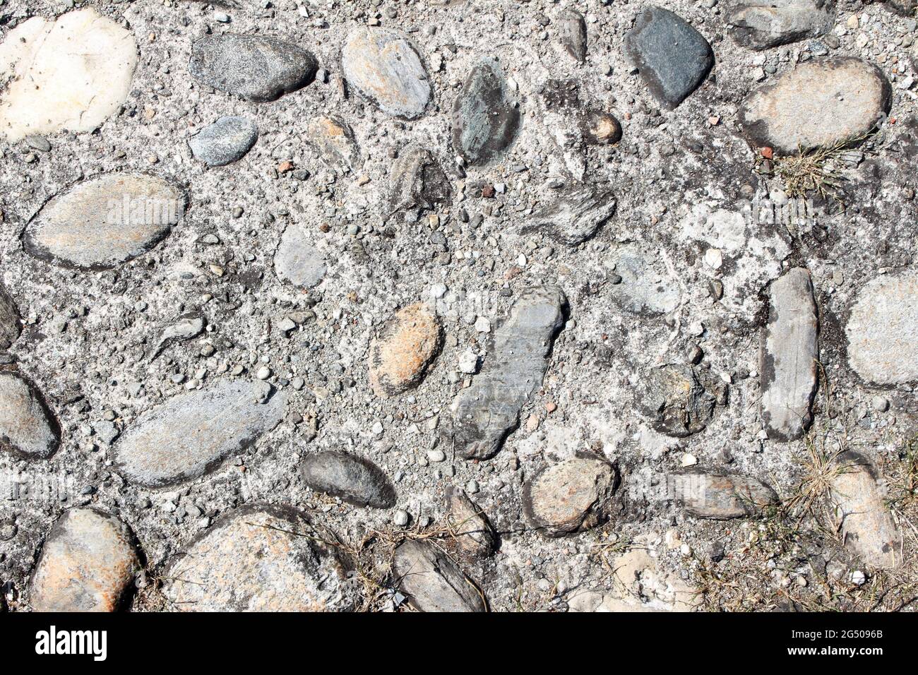 Pedestrian street in stones and cement, abstract texture background. Many granite stones in cement or concrete surface, pattern on exterior building Stock Photo