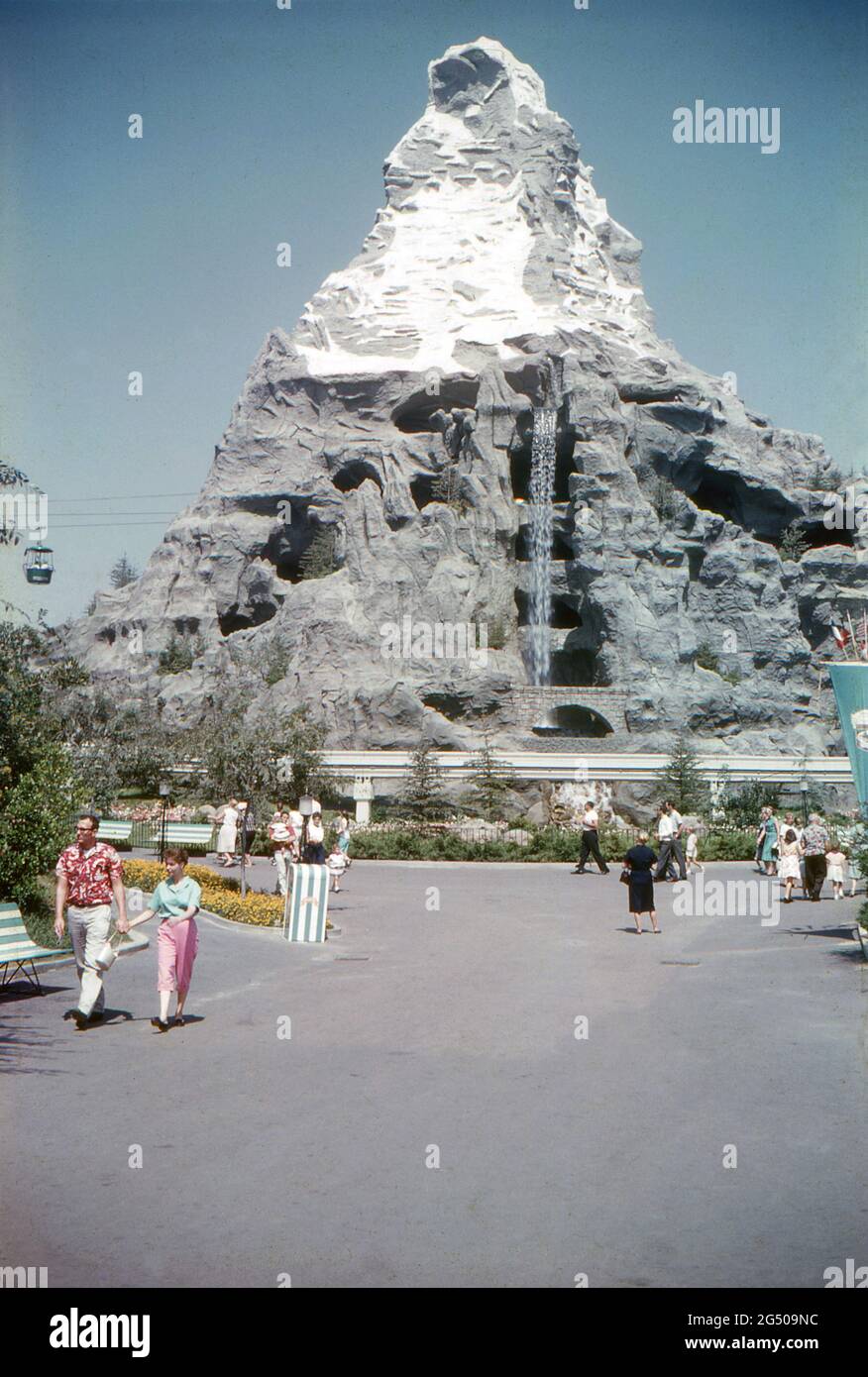 Disneyland, California, 1959. View of the Matterhorn bobsled roller coaster,  taken from the Central Plaza (Hub) shortly after its construction and  displaying its original layout. Visitors are passing by, a waterfall is