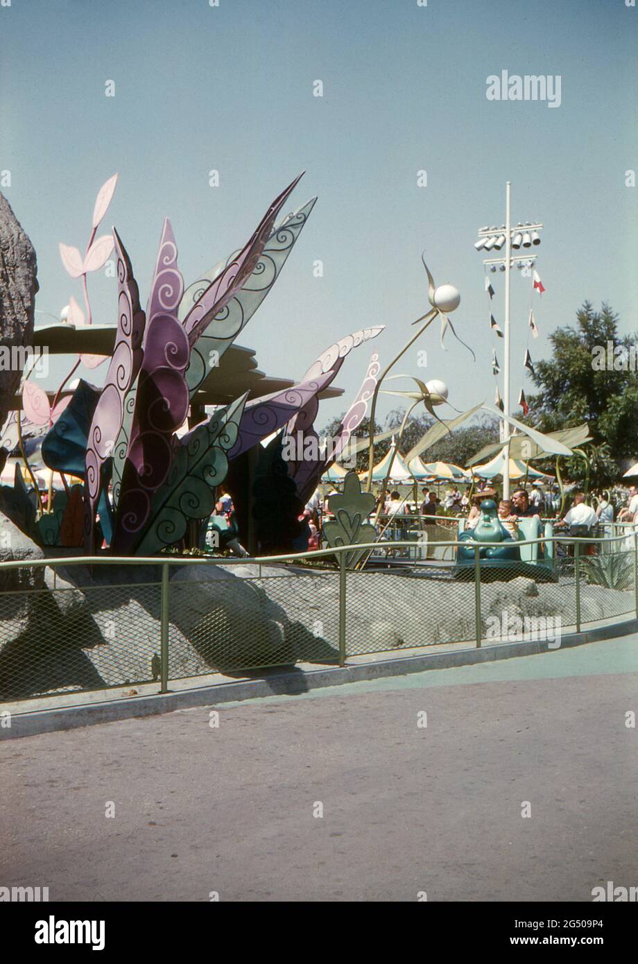 Disneyland, California, 1959. A view of the Alice in Wonderland ride in Fantasyland; this being the original version which was constructed in 1958. A family are riding in one of the attraction’s caterpillar cars and are about to pass giant leafy vines. Stock Photo