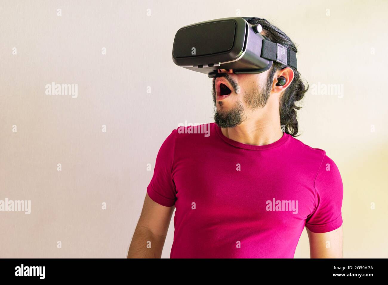 Young latin man using a Virtual Reality Device Glasses at home Stock Photo