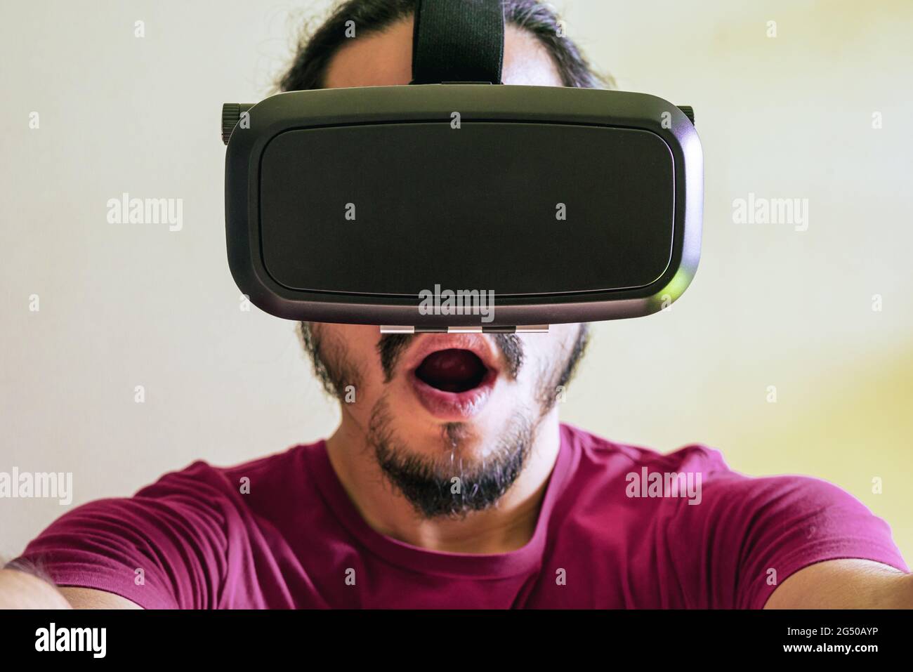 Young latin man using a Virtual Reality Device Glasses at home Stock Photo