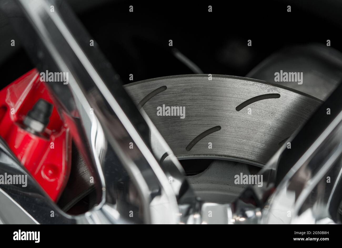 Automotive Industry Theme. Modern Car Brake Disc with Red Caliper Close Up Photo. Performance Vehicle Brakes. Stock Photo